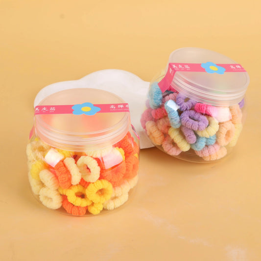 fondo tomate con Ligas para el cabello en frasco tipo Big Belly Cup, coloridas y resistentes. Prácticas para uso diario y venta mayorista.