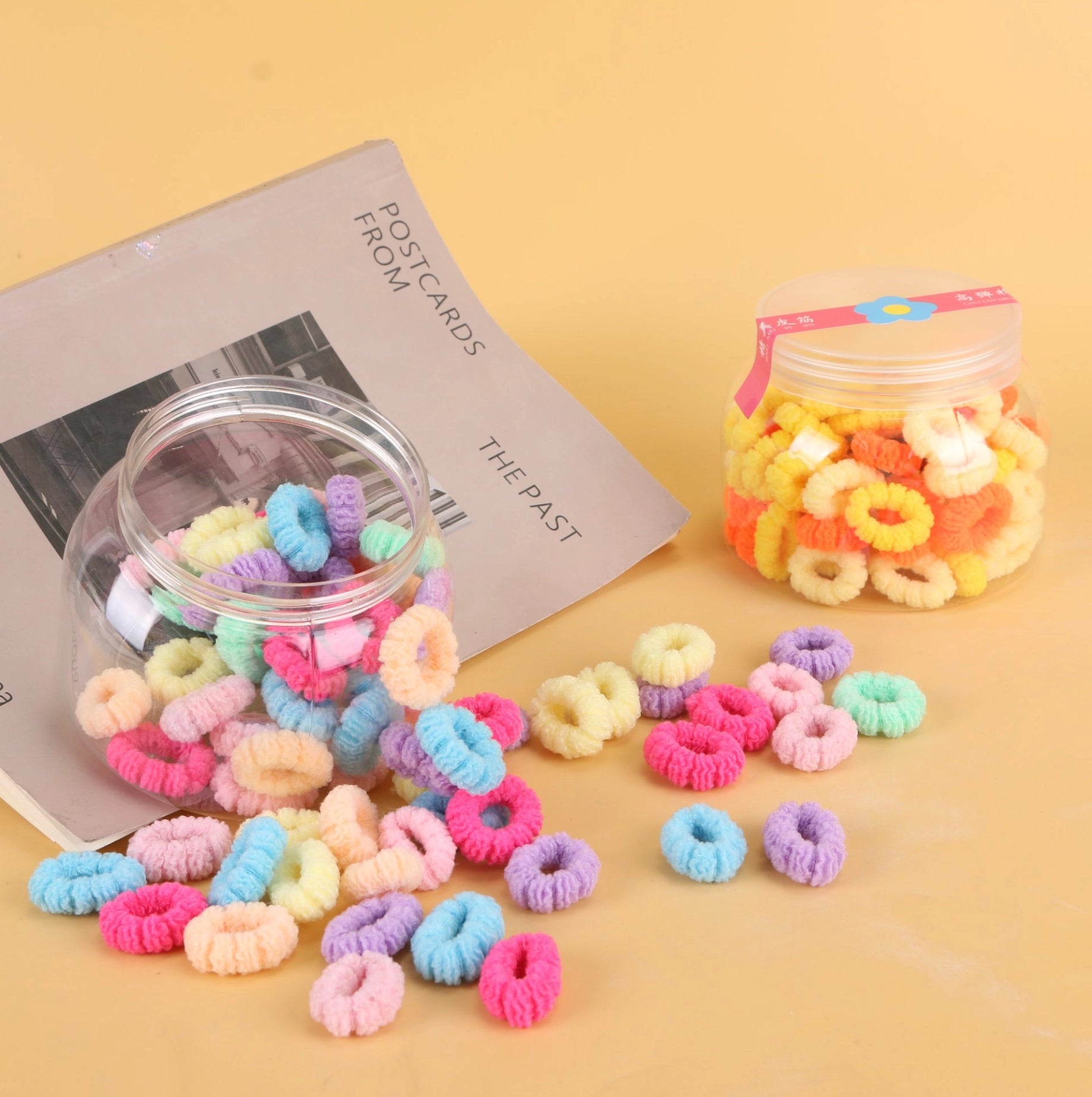 fondo tomate con Ligas para el cabello en frasco tipo Big Belly Cup, coloridas y resistentes. Prácticas para uso diario y venta mayorista.