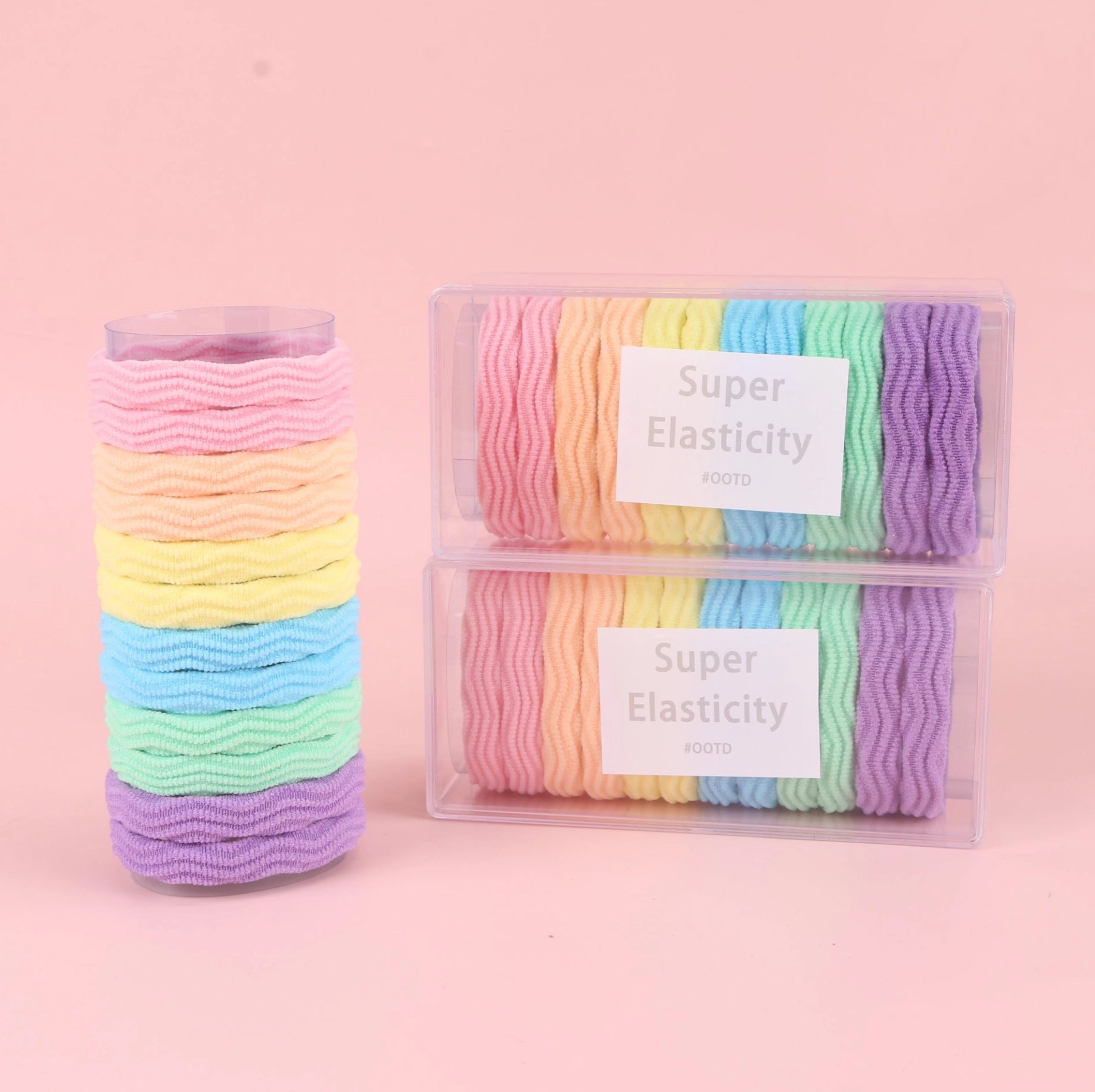 fondo rosa con Ligas elásticas de colores en caja larga tipo jacquard. Presentación ligera y práctica para mayoristas y tiendas de accesorios.