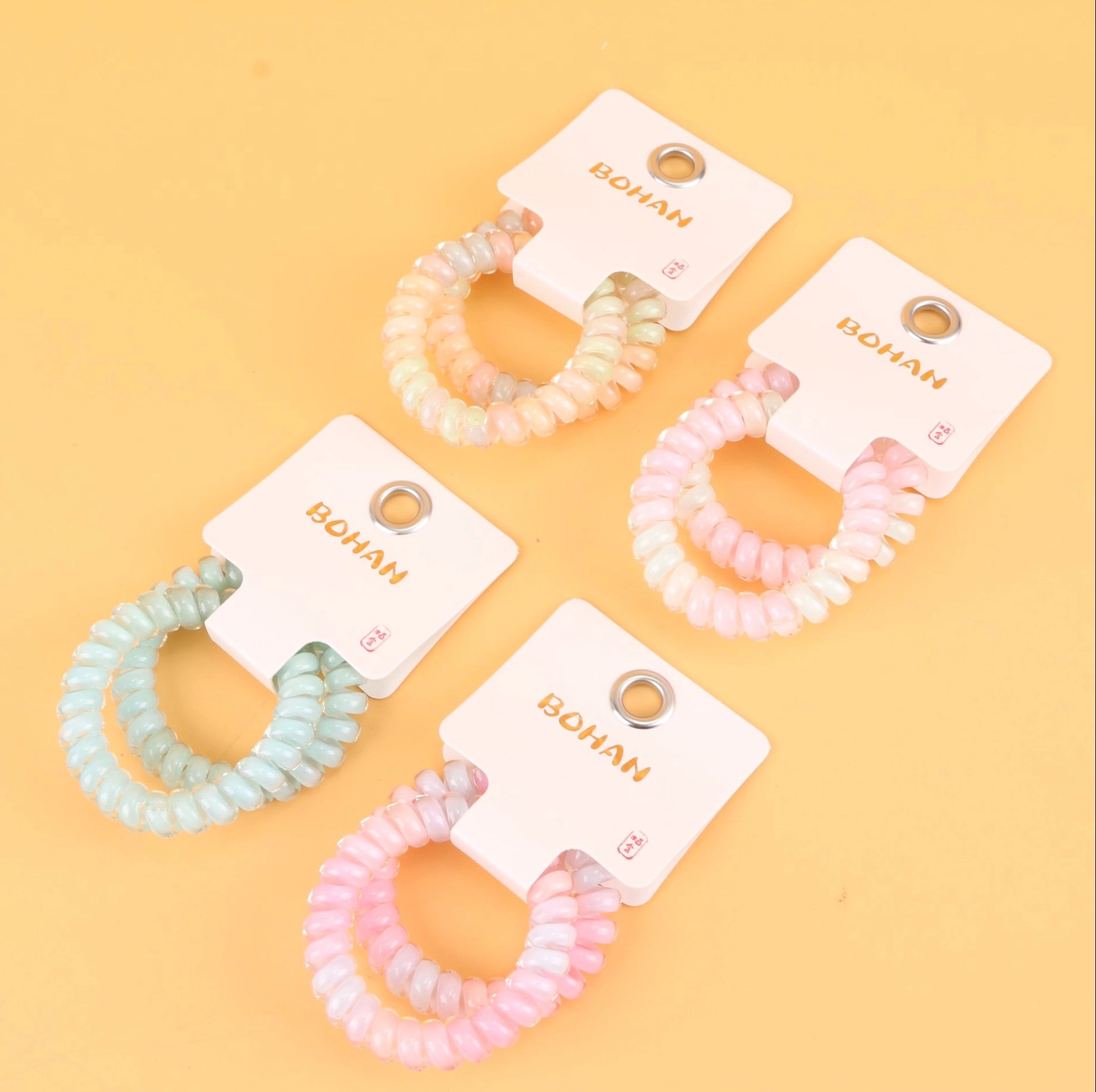 fondo tomate con 4 Ligas para el cabello en espiral tipo cable telefónico, resistentes y coloridas. Ligero set de 21 g, ideal para mayoristas y tiendas de accesorios.