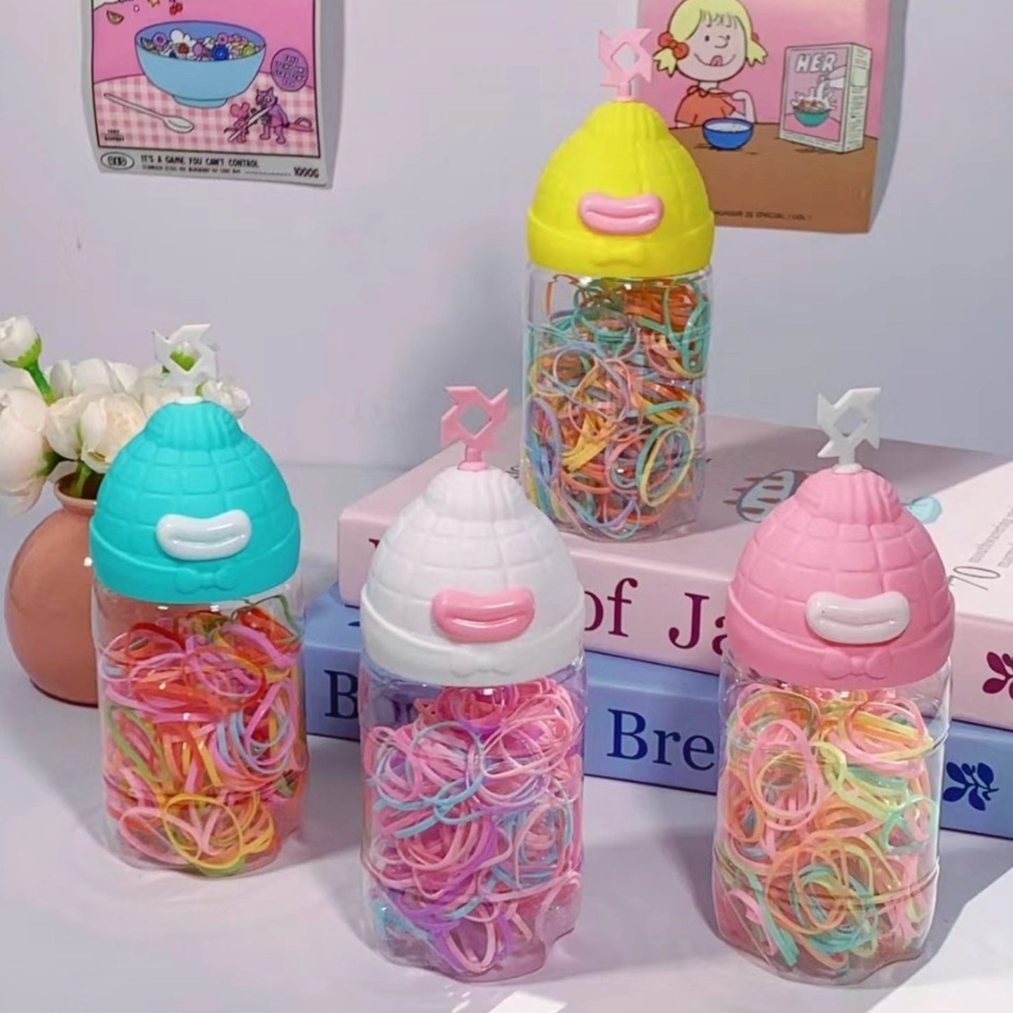 Ligas de colores desechables para cabello en frasco decorativo con tapa de gorro. Caja de 24 unidades, ideal para tiendas y mayoristas.