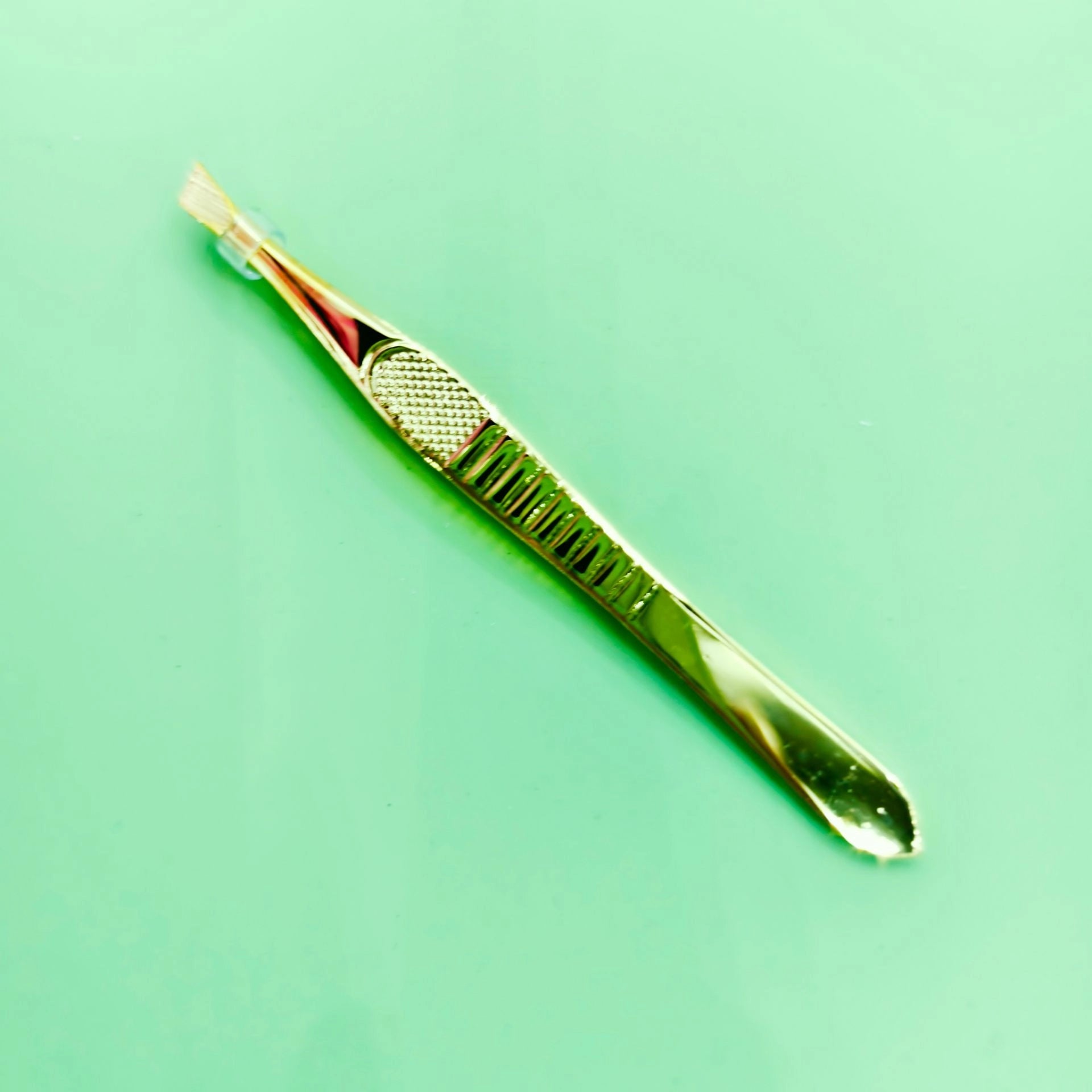 Pinza de cejas dorada de alta calidad, ligera y elegante. Venta en caja individual para mayoristas