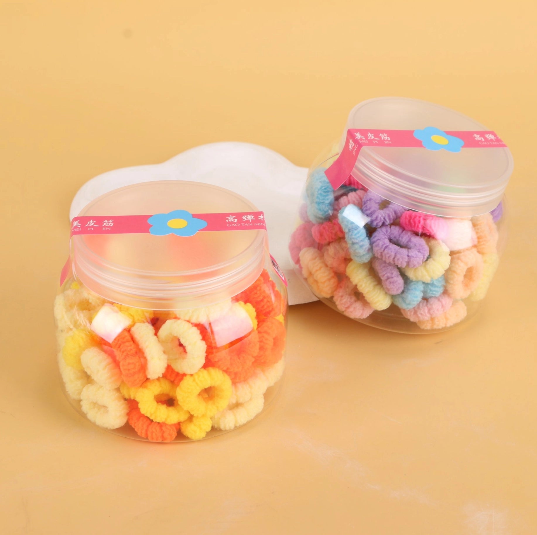 fondo tomate con Ligas para el cabello en frasco tipo Big Belly Cup, coloridas y resistentes. Prácticas para uso diario y venta mayorista.