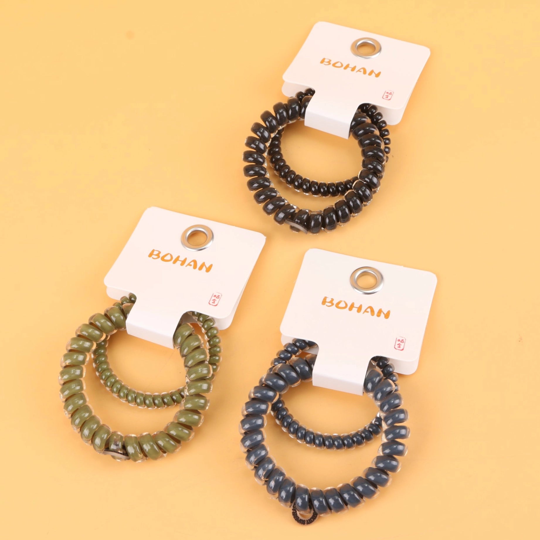 fondo tomate con 3 Ligas para el cabello en espiral doble, resistentes y modernas.